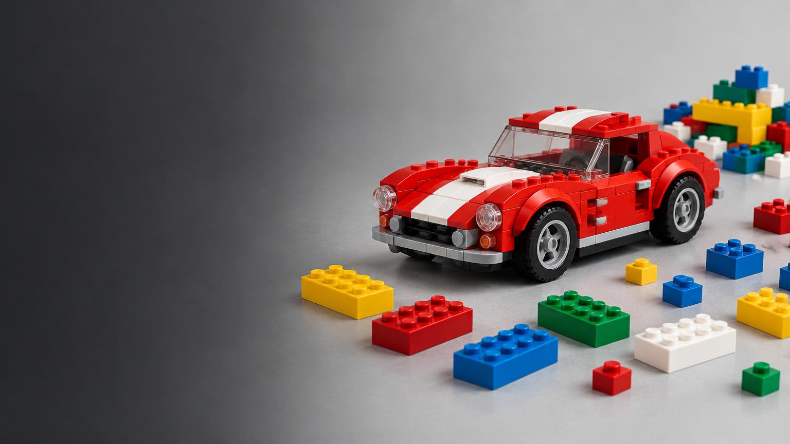 Illustrative brick-built red sports car beside colourful building bricks
